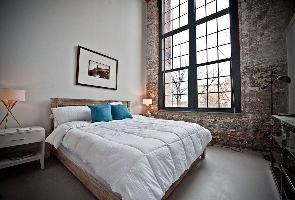 Sypialnia w stylu industrialnym z dużym drewnianym łóżkiem
